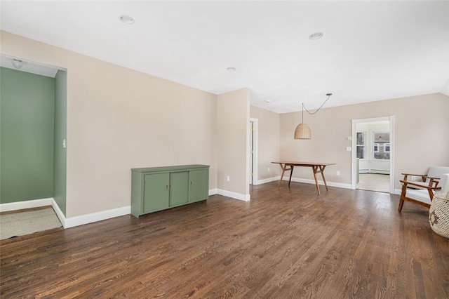 interior space featuring baseboards and dark wood finished floors