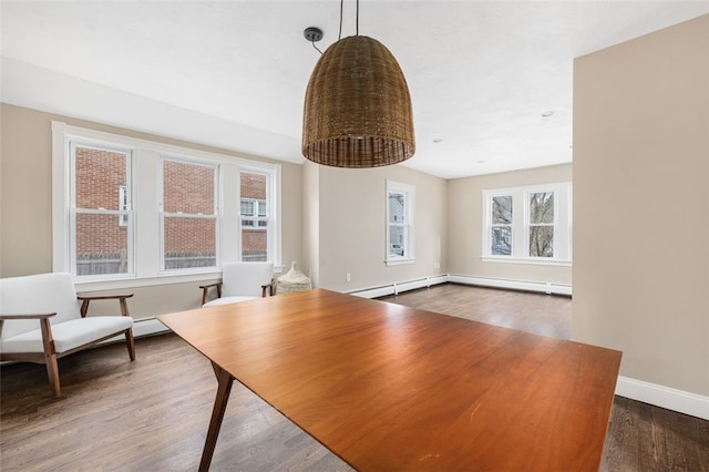 unfurnished dining area with a baseboard heating unit, plenty of natural light, baseboards, and wood finished floors