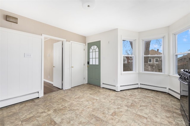 empty room with visible vents, stone finish flooring, and baseboard heating