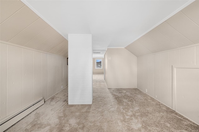 additional living space featuring a decorative wall, carpet, a baseboard radiator, and vaulted ceiling