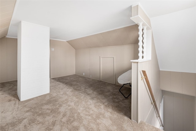 additional living space with a decorative wall, lofted ceiling, and carpet