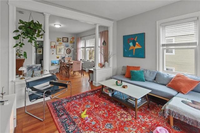living area with ornate columns and wood finished floors
