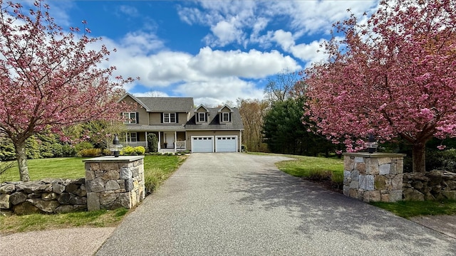view of front facade with a front lawn, driveway, and covered porch