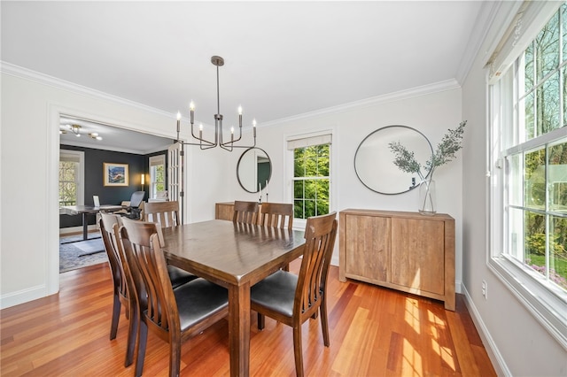 dining room with light wood-style floors, plenty of natural light, and a notable chandelier