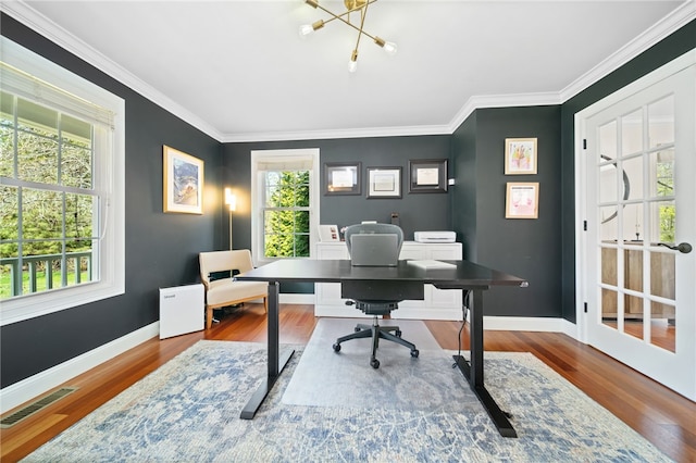office space with an inviting chandelier, baseboards, wood finished floors, and visible vents