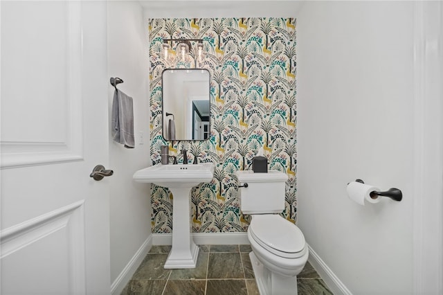 bathroom with baseboards and toilet