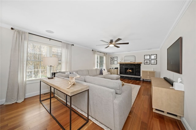 living room featuring a ceiling fan, ornamental molding, and wood finished floors