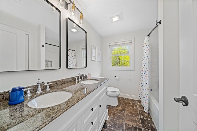 full bathroom with baseboards, a sink, double vanity, and toilet