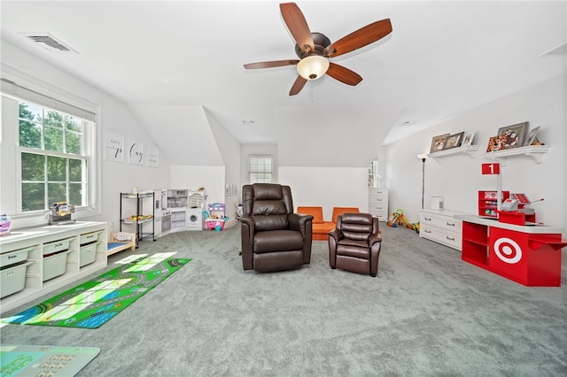 recreation room featuring carpet flooring, ceiling fan, visible vents, and vaulted ceiling