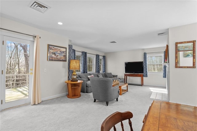 living area featuring visible vents and light carpet