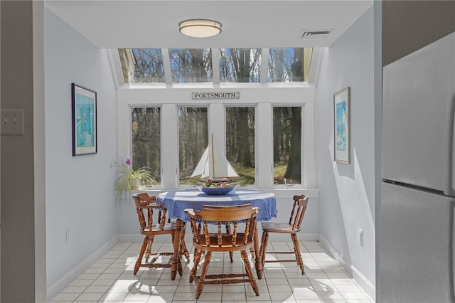 dining room featuring baseboards, visible vents, and light tile patterned floors