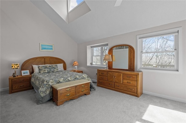 bedroom featuring ceiling fan, light carpet, vaulted ceiling, and baseboards