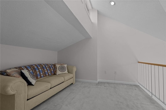 carpeted living room featuring lofted ceiling, a textured ceiling, and baseboards
