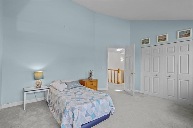 bedroom with high vaulted ceiling, baseboards, carpet flooring, and a closet