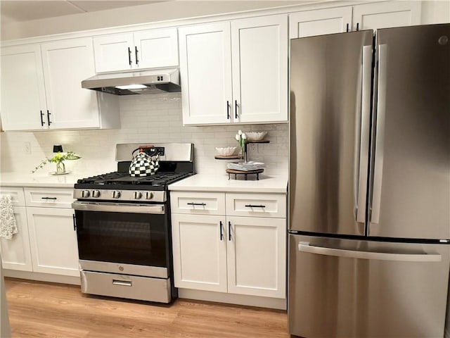 kitchen featuring white cabinets, appliances with stainless steel finishes, under cabinet range hood, light countertops, and decorative backsplash