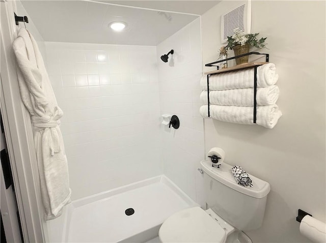 full bathroom featuring a stall shower and toilet