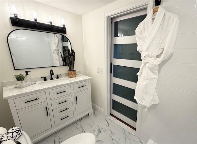bathroom with marble finish floor, baseboards, and vanity