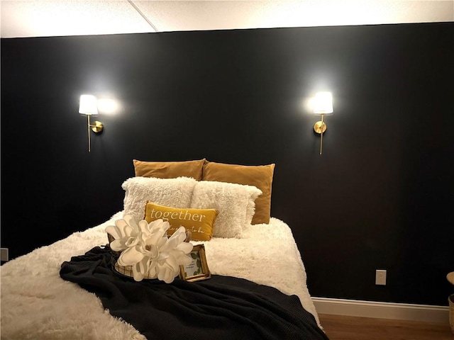 bedroom featuring baseboards and wood finished floors