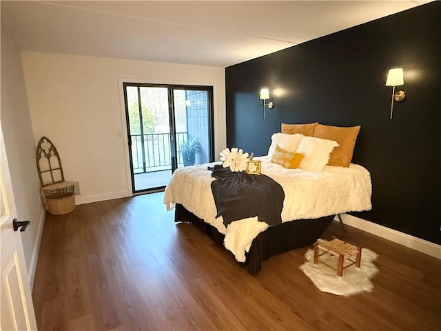 bedroom featuring baseboards, access to outside, and wood finished floors