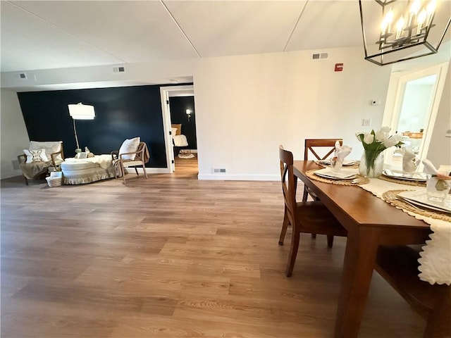 dining room with light wood-type flooring, baseboards, and visible vents