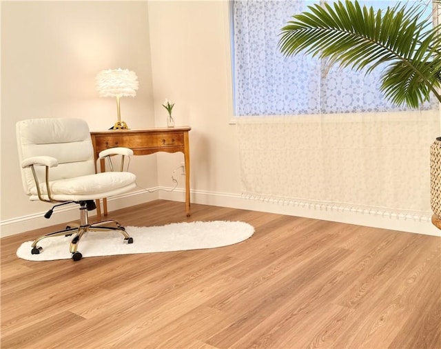 sitting room featuring wood finished floors, baseboards, and wallpapered walls