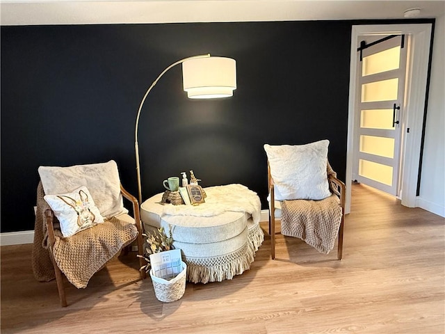 living area with light wood-type flooring and baseboards