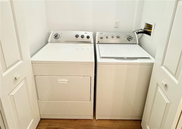 laundry room with laundry area, washing machine and clothes dryer, and dark wood-style flooring