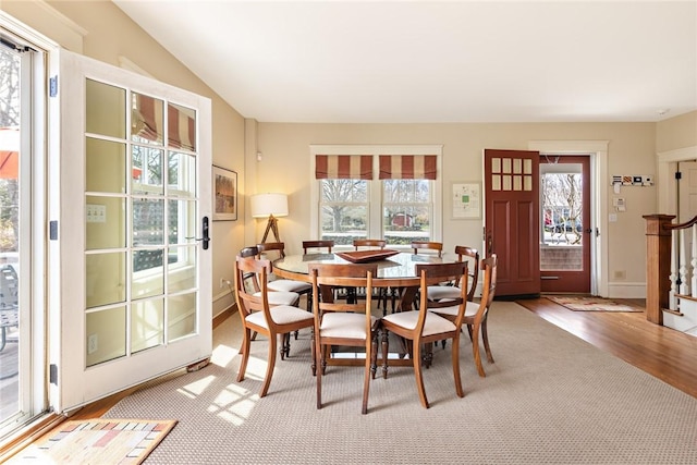 dining space featuring wood finished floors, baseboards, and stairs