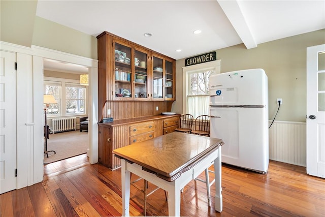 dining room with wainscoting, radiator, and wood-type flooring