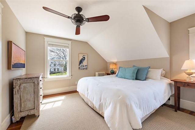 bedroom with radiator, wood finished floors, and baseboards