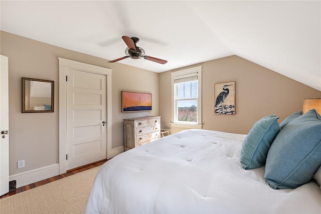 bedroom with ceiling fan, vaulted ceiling, wood finished floors, and baseboards