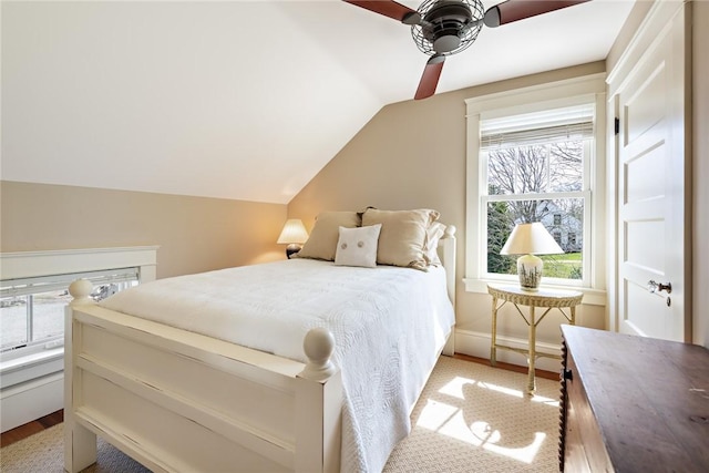 bedroom featuring multiple windows, ceiling fan, vaulted ceiling, and baseboards