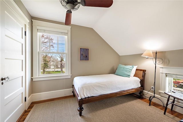bedroom with wood finished floors, ceiling fan, multiple windows, and lofted ceiling