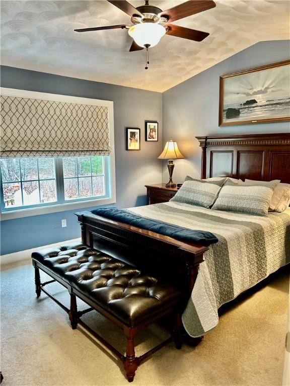 carpeted bedroom featuring vaulted ceiling and ceiling fan