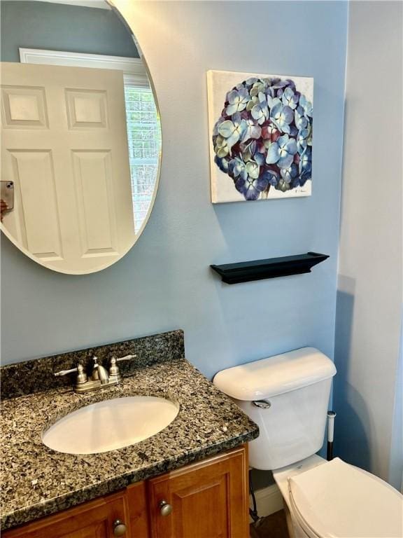 half bathroom featuring toilet and vanity