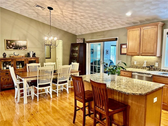 interior space with a textured ceiling, light wood-style floors, an inviting chandelier, visible vents, and recessed lighting