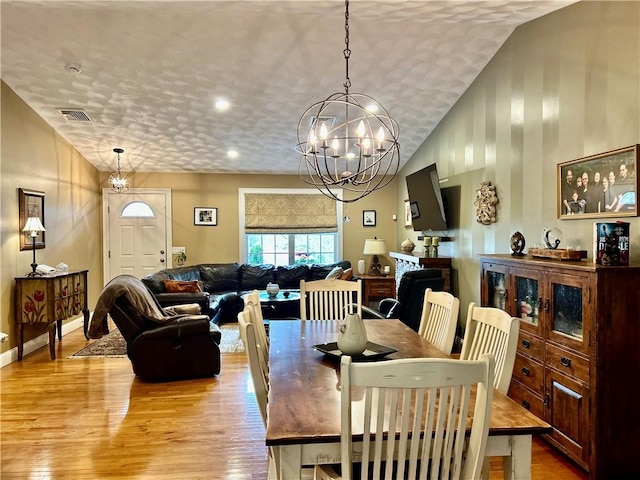 dining room with light wood-style floors and lofted ceiling