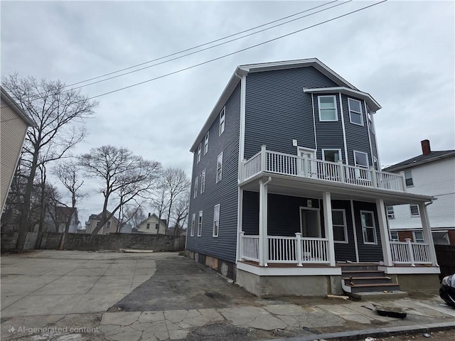 view of property with a balcony and covered porch