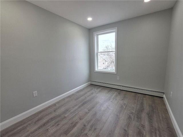 unfurnished room featuring recessed lighting, baseboards, baseboard heating, and wood finished floors