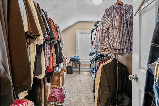 spacious closet featuring baseboard heating, vaulted ceiling, and carpet floors