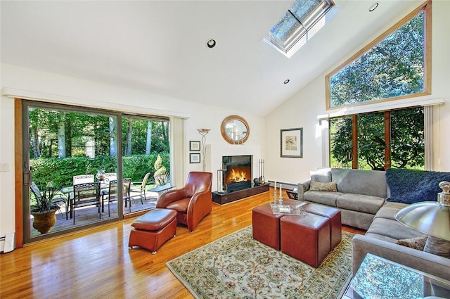 21 Fesser Ave, Bristol, RI 02809 - living room featuring a skylight, a baseboard radiator, wood finished floors, high vaulted ceiling, and a lit fireplace