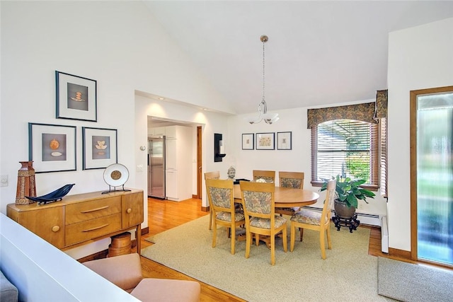 21 Fesser Ave, Bristol, RI 02809 - dining space featuring light wood-style floors, baseboards, high vaulted ceiling, and a notable chandelier