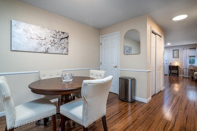 dining area with baseboards and wood finished floors