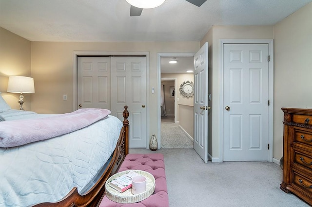 bedroom with baseboards, a closet, light colored carpet, and ceiling fan