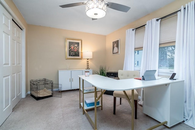 carpeted home office with ceiling fan and baseboards