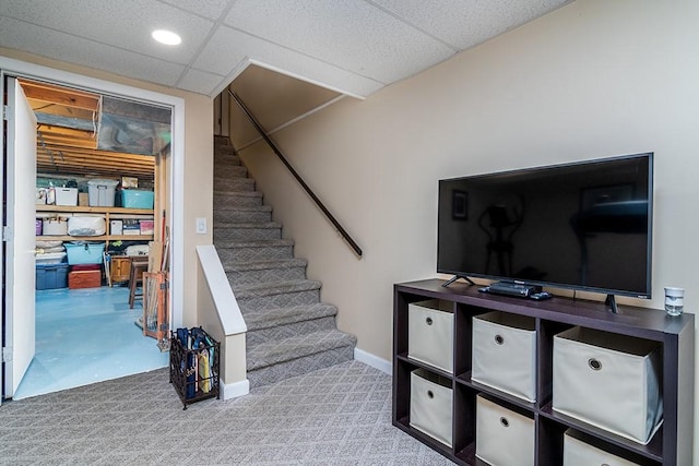 stairs with baseboards, a drop ceiling, and carpet