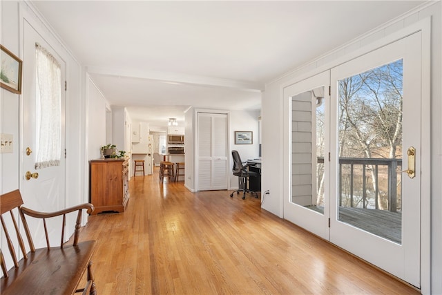 interior space with ornamental molding and light wood finished floors