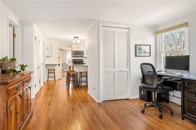 office with light wood-type flooring, a wealth of natural light, crown molding, and baseboards