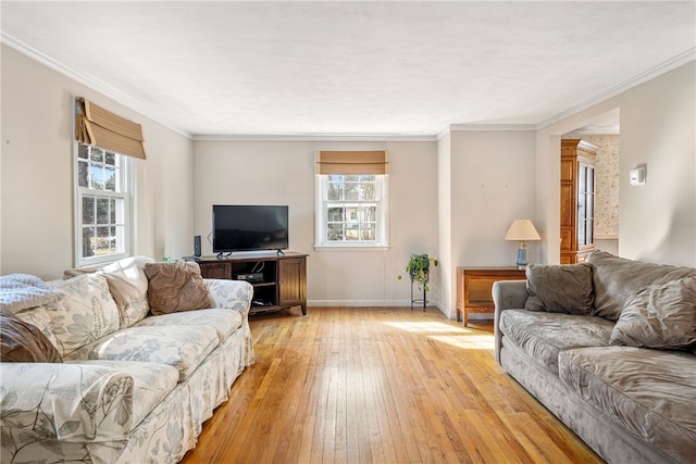 living room with light wood-style floors, crown molding, and baseboards