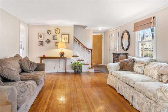living room featuring light wood-style floors, stairway, crown molding, and baseboards